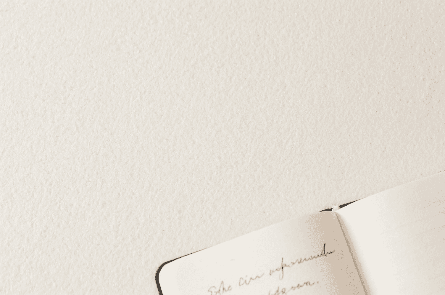 Topdown view of a woman's hands writing in a textbook